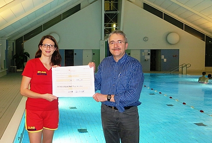 Scheckübergabe an Saskia Krugmann (Vorsitzende des DLRG Bad Rappenau) durch ÖDP Stadtrat Klaus Ries-Müller während des Schwimmtrainings in der Vesalius Klinik