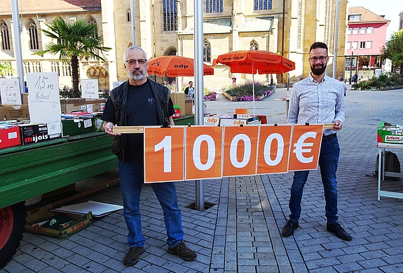 Johannes Born von den Nordstadtkids (rechts) und Uli Stein von ÖDP Kreisverband Heilbronn vor einem Traktoranhänger mit Büchern 