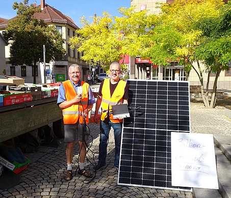 Von links: Klaus Ries-Müller (aus Bad Rappenau) mit dem Anschlussstecker und Uli Stein (aus Heilbronn) mit dem Wechselrichter, rechts: Module mit maximal 400 Watt, links: Der Traktoranhänger mit den Gebrauchtwaren. 